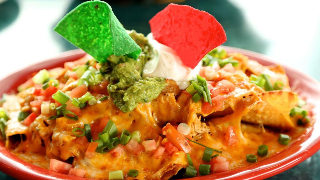 Super Nachos With Meat · Corn tortilla chips with refried beans, choice of ground beef, or chicken, melted cheese, chopped tomatoes, green onions, guacamole, and sour cream.