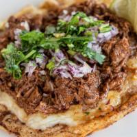 Birria Gordita · Handmade corn tortilla topped with Monterey Jack cheese, shredded beef, diced red onion and ...