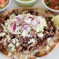 Steak Tostada · Crisp corn tortilla topped with melted Monterey Jack cheese, mesquite grilled carne asada, d...