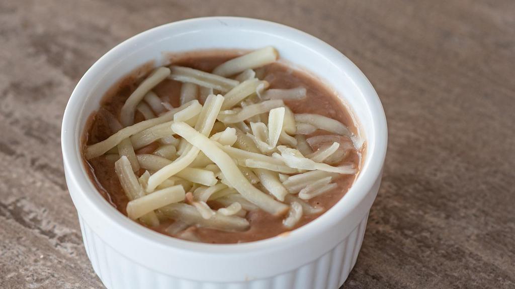 Refried Beans · Refried Beans topped with Monterey Jack cheese.