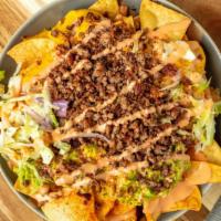 Solár Loaded Nachos · Large plate of nachos topped with Impossible Meat, house specialty coleslaw, guacamole aioli...