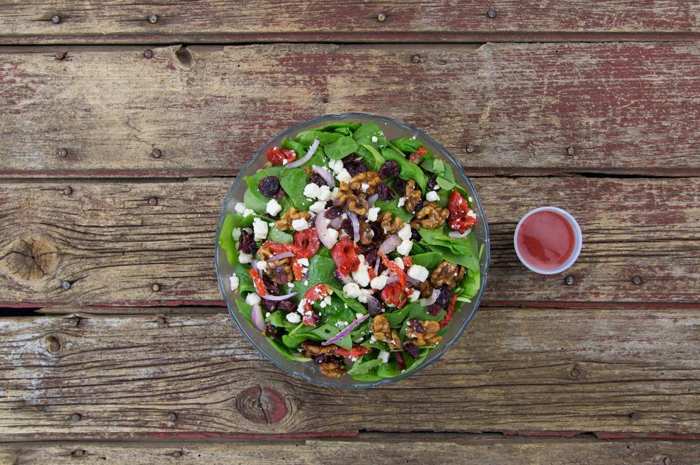Spinach Salad · Fresh baby spinach, roasted red peppers, candied walnuts, feta cheese, red onions and dried cranberries and raspberry vinaigrette dressing.