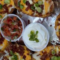 Potato Skins (6) · topped with shredded Colby Jack Cheese, Bacon and Green Onions served with sour cream.
