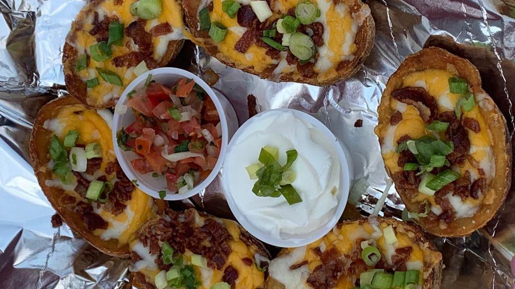 Potato Skins (6) · topped with shredded Colby Jack Cheese, Bacon and Green Onions served with sour cream.