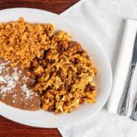 Huevos Con Chorizo · Spicy Mexican sausage fried with onions and tomatoes in scrambled eggs served with rice and ...