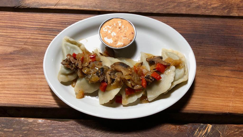 Spinach Pierogies · Boiled or fried, stuffed with feta and spinach. Garnished with mushrooms, onions, garlic, and red pepper flake. Served with a side of spicy pierogi sauce.