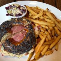 Reuben Sandwich · Corned beef topped with melted gruyere, Russian dressing, kraut, and coleslaw served on a pr...