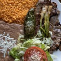 Carne Asada  · Served with rice beans lettuce tomatoes cheese and tortillas.