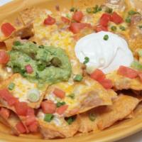 Vegetarian Super Nachos · Corn tortilla chips topped with whole beans, jalapeno poppers, green onions, and melted chee...