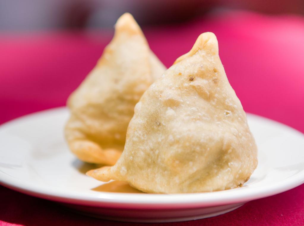 Vegetable Samosa (2 Pieces) · Golden brown fried pastries with stuffing of potato, green peas,  and our chef’s blend of exotic herbs and spices. Served with red (tamarind) chutney or green (cilantro and mint) chutney.
