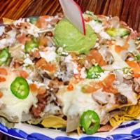 El Dorado Nachos · House tortilla chips topped with refried beans, Oaxacan & Monterey Jack cheese, fresh guacam...