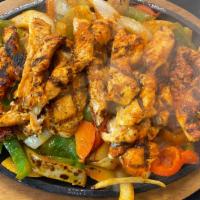 Grilled Chicken · Served over a bed of fresh-cut grilled peppers & onions on a sizzling skillet with fresh gua...
