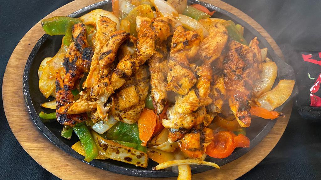 Grilled Chicken · Served over a bed of fresh-cut grilled peppers & onions on a sizzling skillet with fresh guacamole, sour cream, pico de gallo & your choice of flour or corn tortillas. Served with cilantro rice & refried beans. Gluten-free.