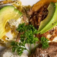 Huevos Divorciados · Two fried eggs over fried corn tortillas with fresh Hass avocados, refried beans, queso fres...