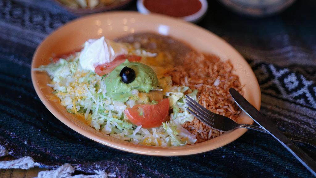 Chimichanga · Crisp, spicy pork, chicken, beef, or seafood burrito topped with lettuce, cheese, tomatoes, sour cream, and guacamole. Served with refried beans and Spanish rice.