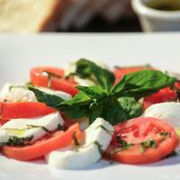 Caprese · Fresh mozzarella, tomato slices & basil, with a drizzle of extra virgin olive oil and sea salt