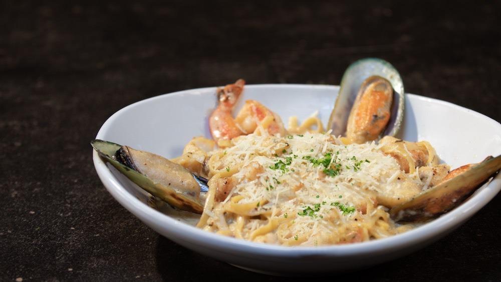 Linguine Di Mare · Wild prawns, seasonal wild caught fish, scallops, mussels & linguine pasta, tossed with your choice of Romano cream sauce OR spicy tomato broth, topped with Romano cheese
