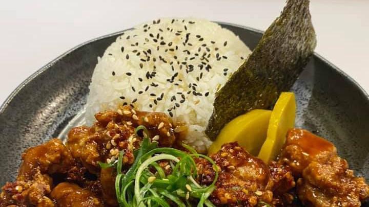 Spicy Chicken Karaage Don · Japanese Style spicy chicken with teriyaki sauce over rice, top with green onion, nori, takuan, sesame