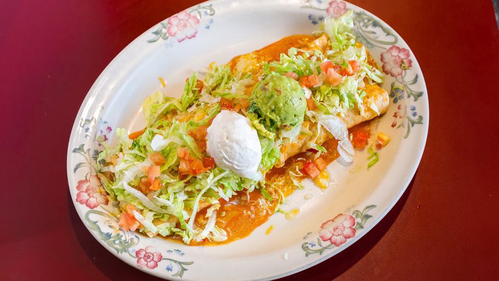 Super Burrito · Soft flour tortilla filled with rice, beans, cheese, beef or chicken, covered with Spanish sauce, melted cheese. Garnished with fresh lettuce, tomatoes, guacamole and sour cream.