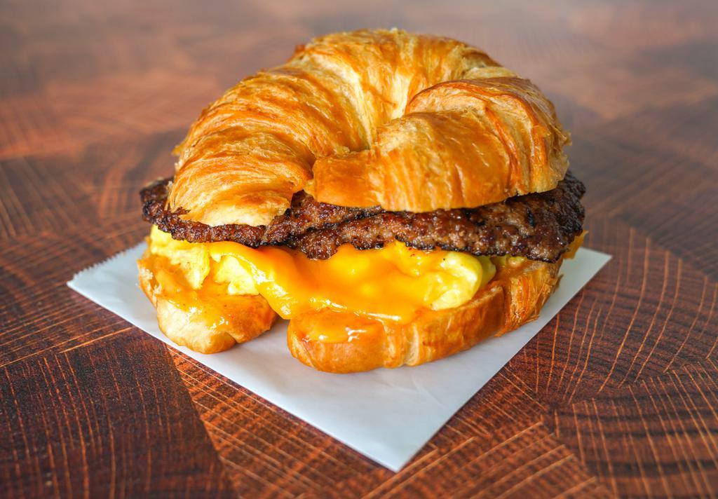 Croissant, Sausage, Egg, & Cheddar Sandwich · 2 scrambled eggs, melted Cheddar cheese, breakfast sausage, and Sriracha aioli on a warm croissant.