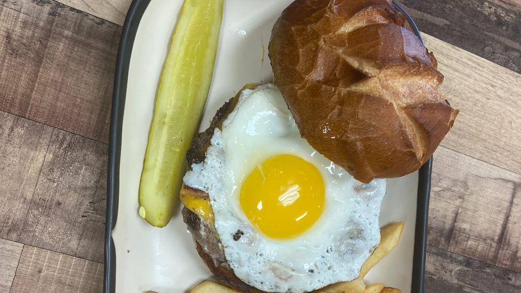 Bacon, Egg, & Cheese Burger · 1/3 pound Angus Beef patty topped with American cheese, crispy bacon, and a sunny side up egg on a soft pretzel bun.