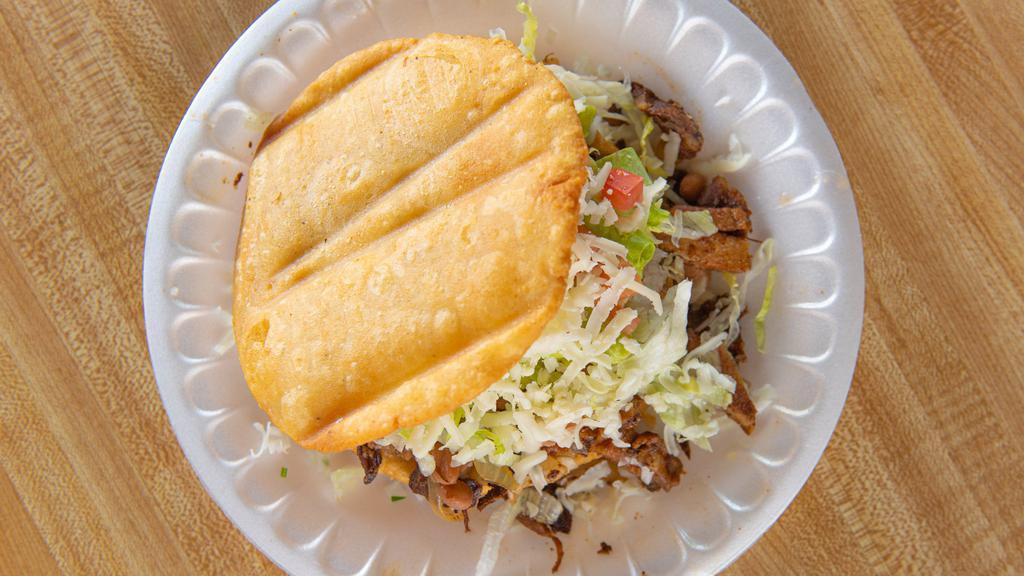 Gordita & Taco Combo · Two deep fried masa tortillas topped with beans meat lettuce onions hot sauce cheese guacamole with a side taco rice and beans.