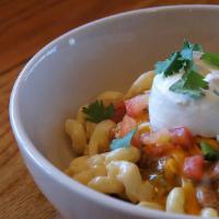 Green Chile Mac & Cheese · Creamy mac & cheese topped with Pork Green Chili, mixed with cheese, pico de gallo, sour cre...