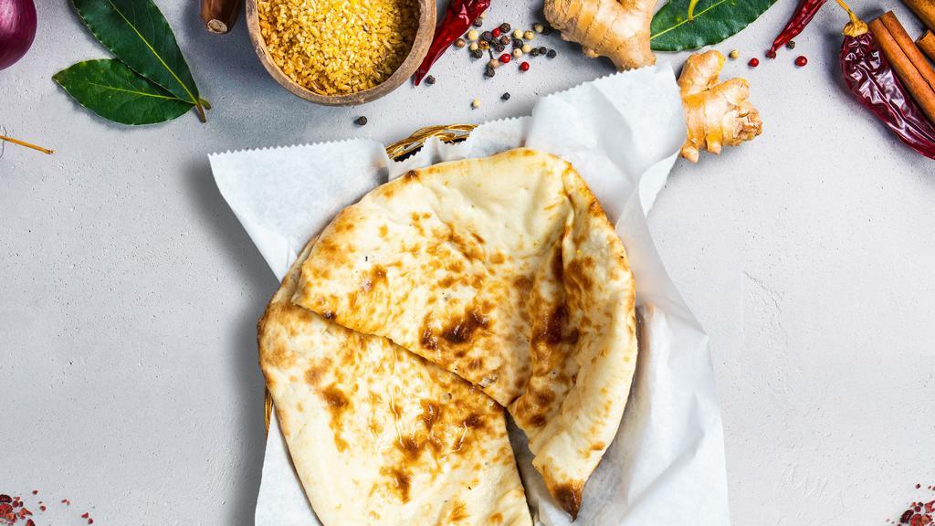 Butter Lovin' Naan · Freshly baked bread in a clay oven garnished with butter