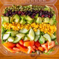 Compassionate Cobb · Bed of power greens topped with tomatoes, cucumber, avocado, corn, pumpkin seeds, dried cran...
