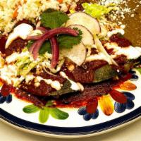 Enchiladas · Three heirloom corn tortillas filled with your favorite stew, smothered in a salsa adobada, ...