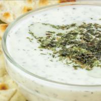 Tzatziki & Pita · Homemade tzatziki sauce and a piece of warm pita bread.