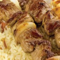 Lamb Kebab · Grilled lamb skewers served with rice, salad, sauces and pita bread.