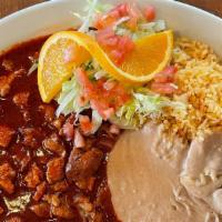 # 43 Pork And Red Chili · Red chili and pork, Served with beans, rice, lettuce, tomatoes, orange slice and tortillas.