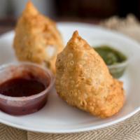 Nirvana Samosas · Deep-fried crispy pastry turnover filled with mashed potato and peas served with tamarind ch...