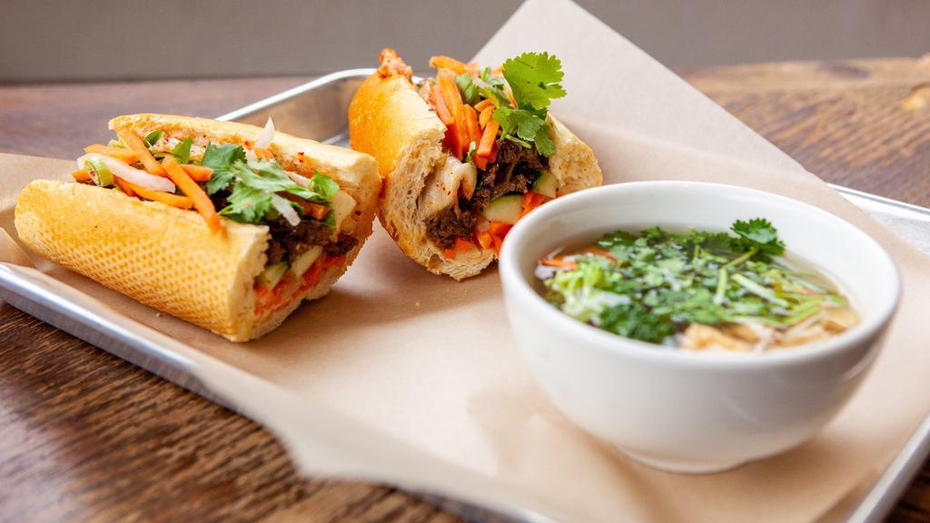 Banh Mi Combo - Pork Belly · Grandma's crisp and tender marinated pork belly in crisp airy French baguette. Stuffed with pickled carrots, cucumbers, green onion, cilantro, housemade aioli, secret sauce, and optional jalapenos. Served with cup of pho OR salad.