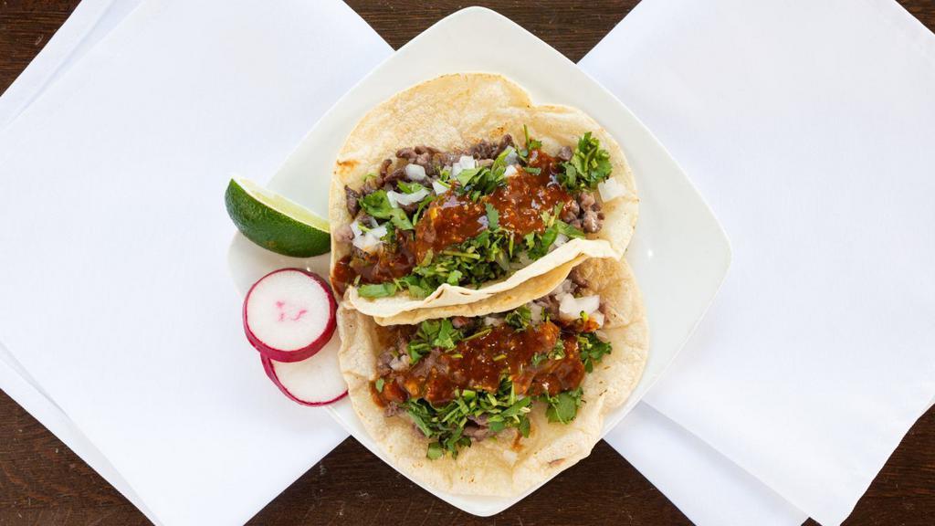 Carne Asada Tacos · Two steak tacos. Topped with cilantro, onion, and salsa.