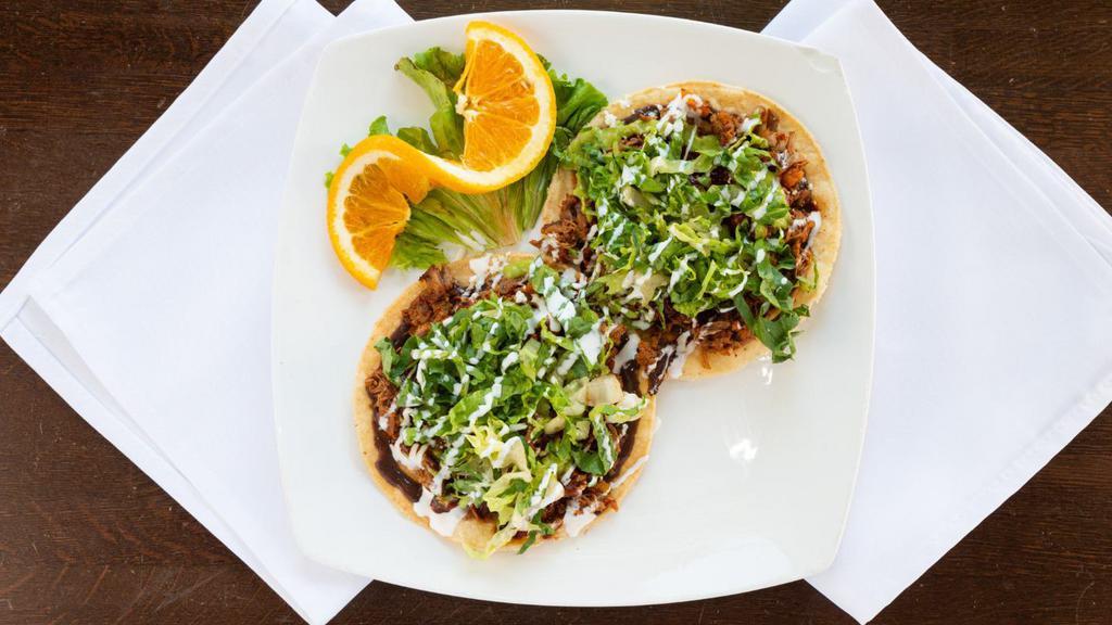 Tostadas De Tinga · Shredded beef. Topped with lettuce, guacamole, crema, queso fresco, and mild salsa.