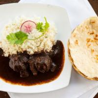 Mole Negro Oaxaqueno · The house specialty. Black mole with chicken or pork. Served with rice and tortillas.