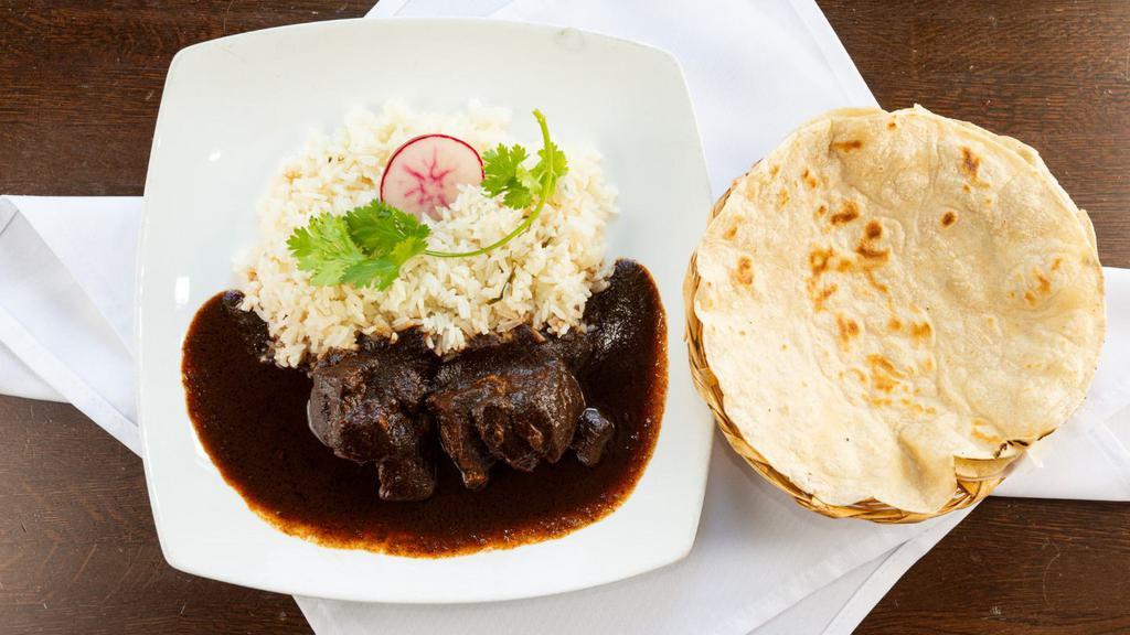 Mole Negro Oaxaqueno · The house specialty. Black mole with chicken or pork. Served with rice and tortillas.