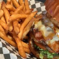 Texas Burger · 1/3 lb cheeseburger with bacon, ham, fried egg, lettuce, tomato and onion ring BBQ sauce on ...