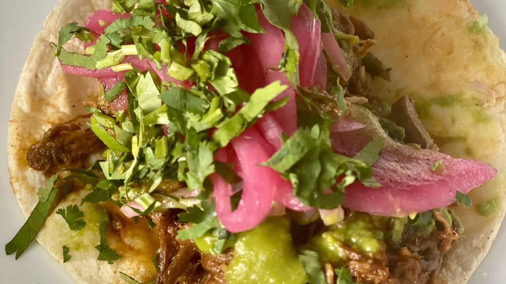 Barbacoa Tacos · Three braised beef in chile and spice tacos, avocado-jalapeno salsa, pickled red onion, and cilantro. Served with three local white corn tortillas, rice & beans. (spicy-leave off avocado-jalapeno salsa to make it not spicy)