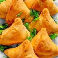 Veg Samosa · Deep fried crispy pastry filled with mashed potatoes and peas.