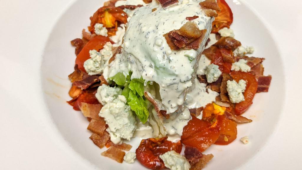 Wedge Salad · Iceberg wedge, bleu cheese crumbles, roasted Roma tomatoes, Nueske's bacon, homemade bleu cheese dressing