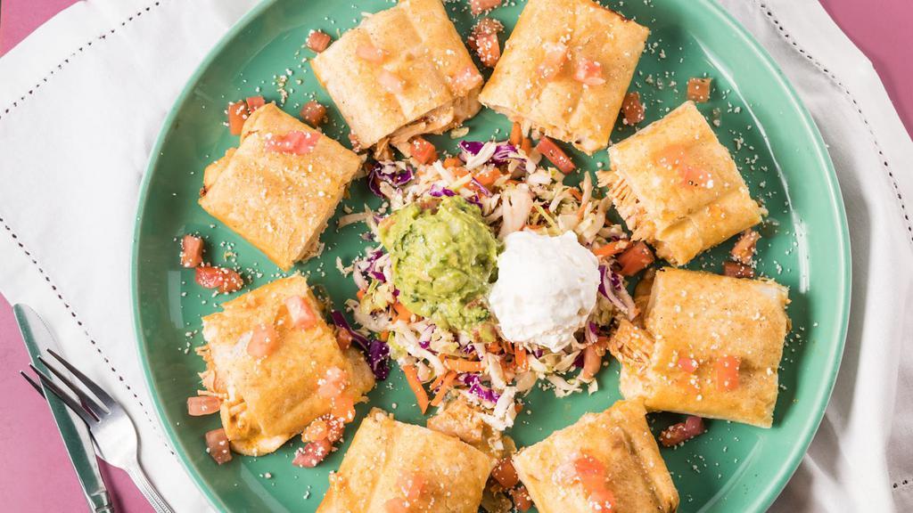 Chicken Taquitos · Two rolled flour tortillas stuffed with chicken and jack cheese, served crispy. Garnished with tomatoes, cotija Mexican cheese, sour cream and guacamole.