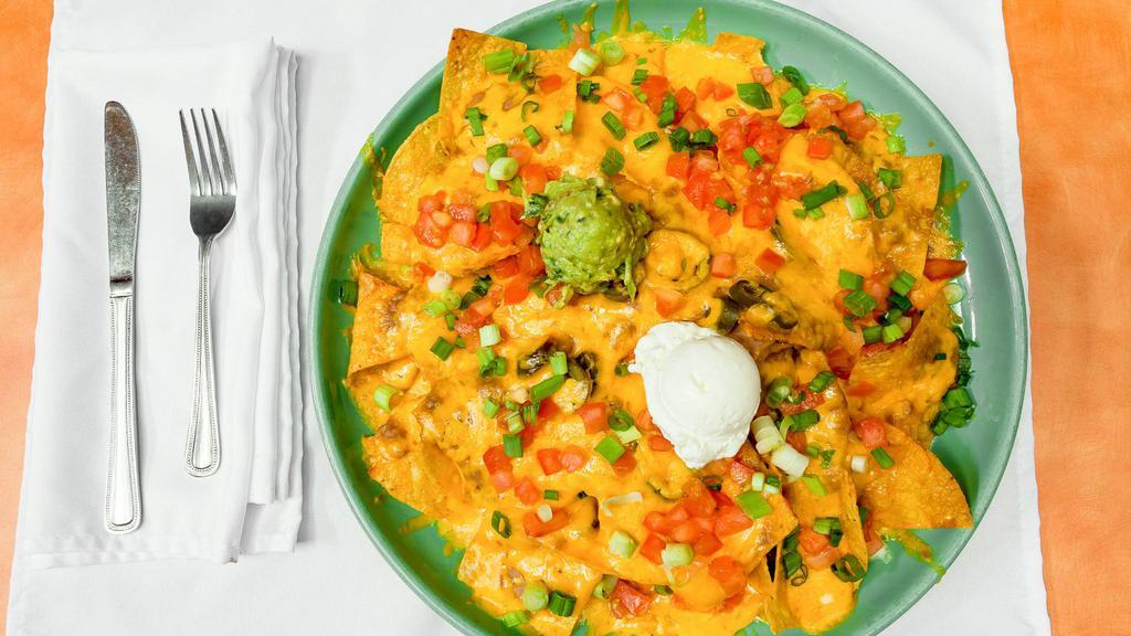 Nachos Azteca™ · Azteca's award winning nachos! Crisp, corn tortilla chips topped with beans, jalapeños and melted cheddar cheese. Garnished with tomatoes, green onions, sour cream and guacamole.