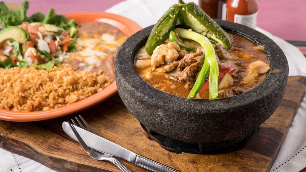Molcajete™ · A Mexican style stew of chicken or steak (or choose a combination of chicken and steak) sautéed in a mildly spicy sauce with mushroom, onions and tomatoes. Topped with melted jack cheese. Garnished with sliced avocado.