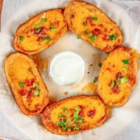 Potato Skins · An instant classic! Our skins our covered with melted cheese, bacon, and chives. Try an orde...