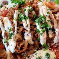 Gyro Salad · Traditional lamb and beef gyro cooked with onion, served over a Greek salad.