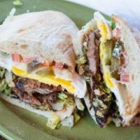 Torta · Grilled torta roll, mayo, refried black beans, Swiss cheese, lettuce, jalapeños, sliced avoc...