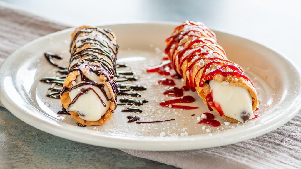 Cannoli Raspberry/Chocolate · Cylindrical Sicilian style pastry shells filled with a creamy ricotta and chocolate chip filling, topped with a rich flavored chocolate or raspberry syrup and sprinkled with powdered sugar.